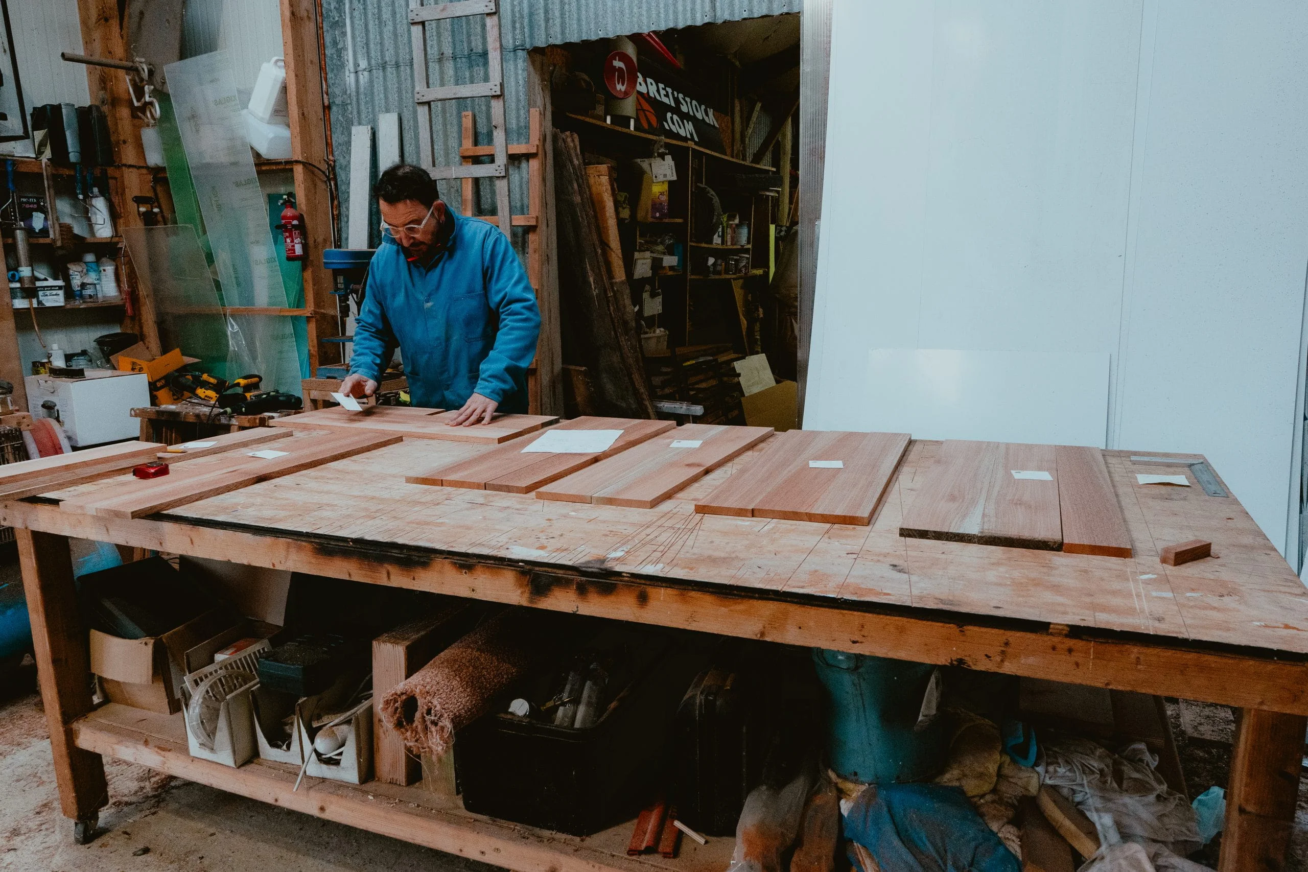 L’atelier KoadBooth à Plouguenast : un menuisier prépare des planches de bois massif sur l’établi