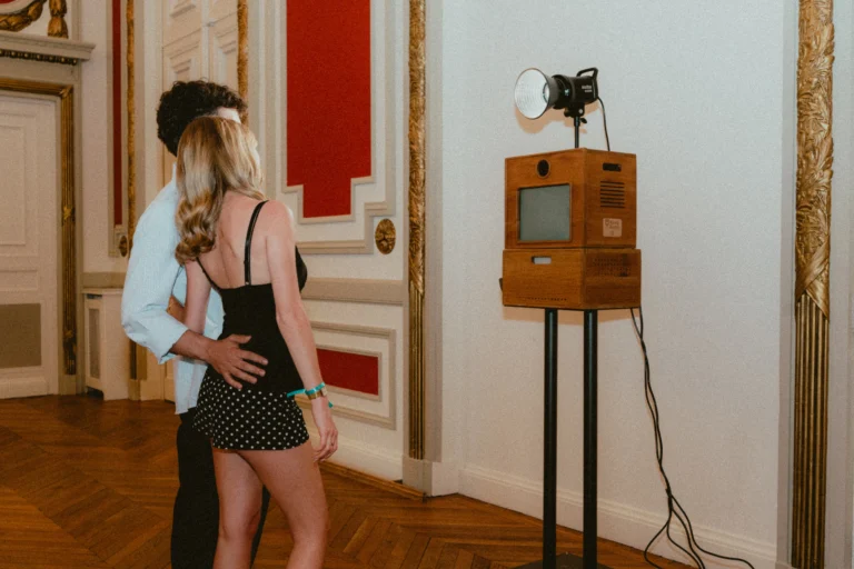 Couple posant devant le photobooth Koadbooth dans un salon haussmannien