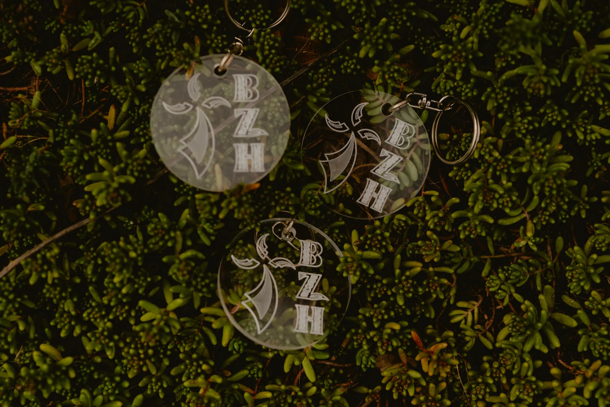 Trois porte-clés ronds en plexiglas transparent, gravés d'une hermine et des lettres BZH.
